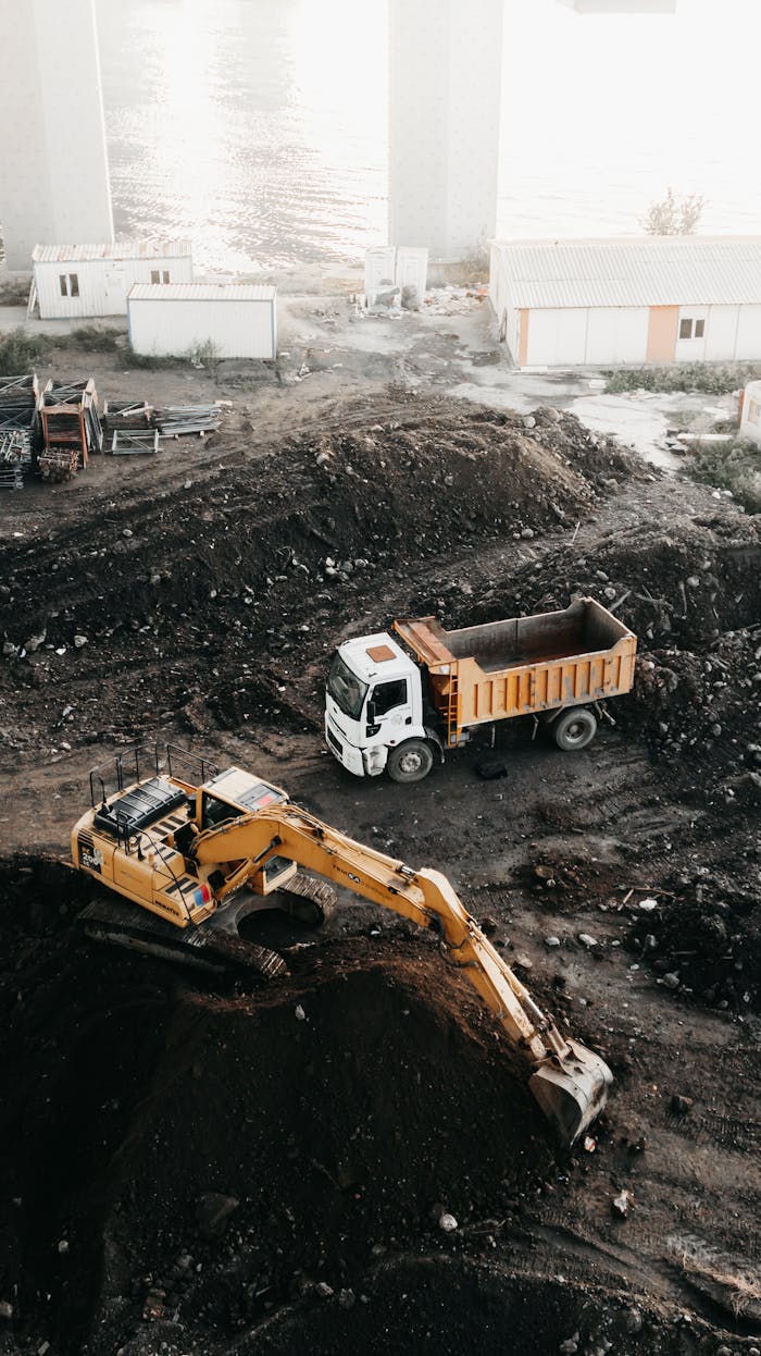 A high angle view of a construction site in Istanbul featuring an excavator and a truck.